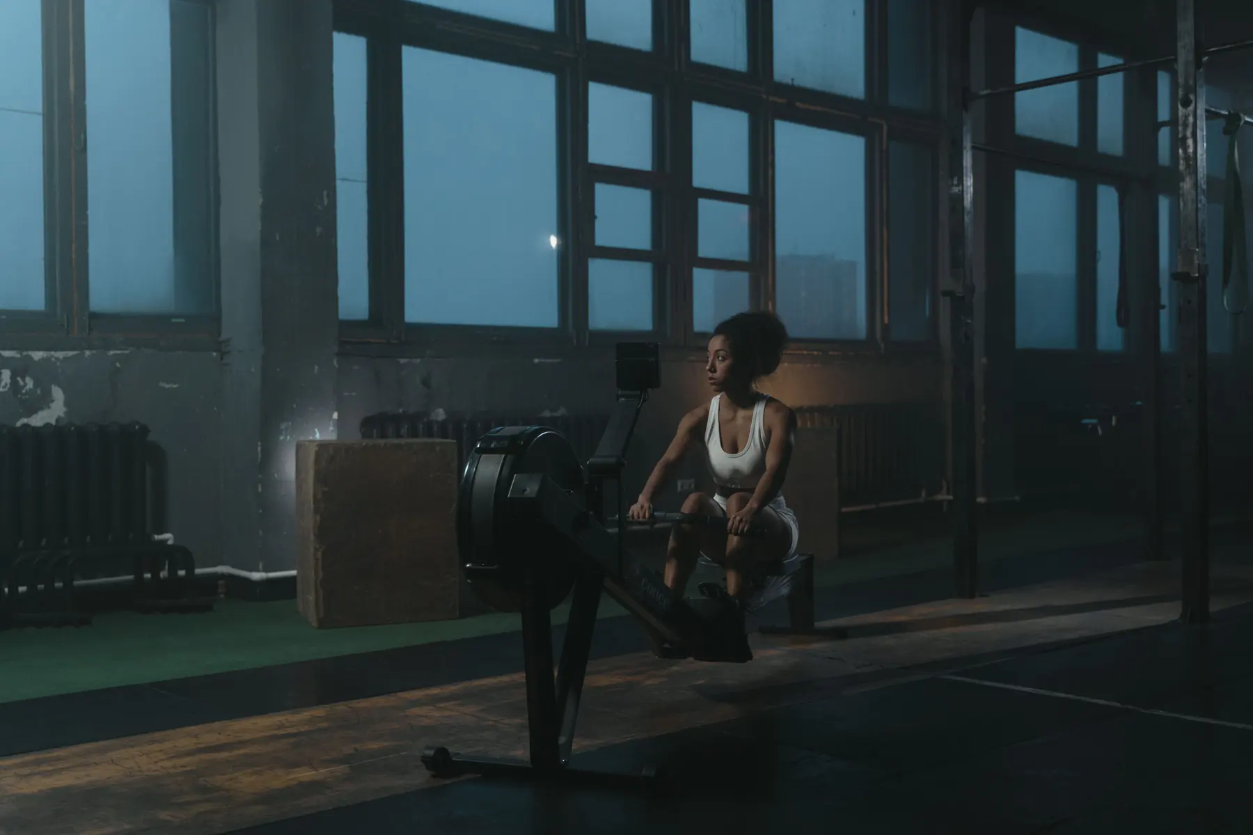 An athlete rows in the engine room beside the windows