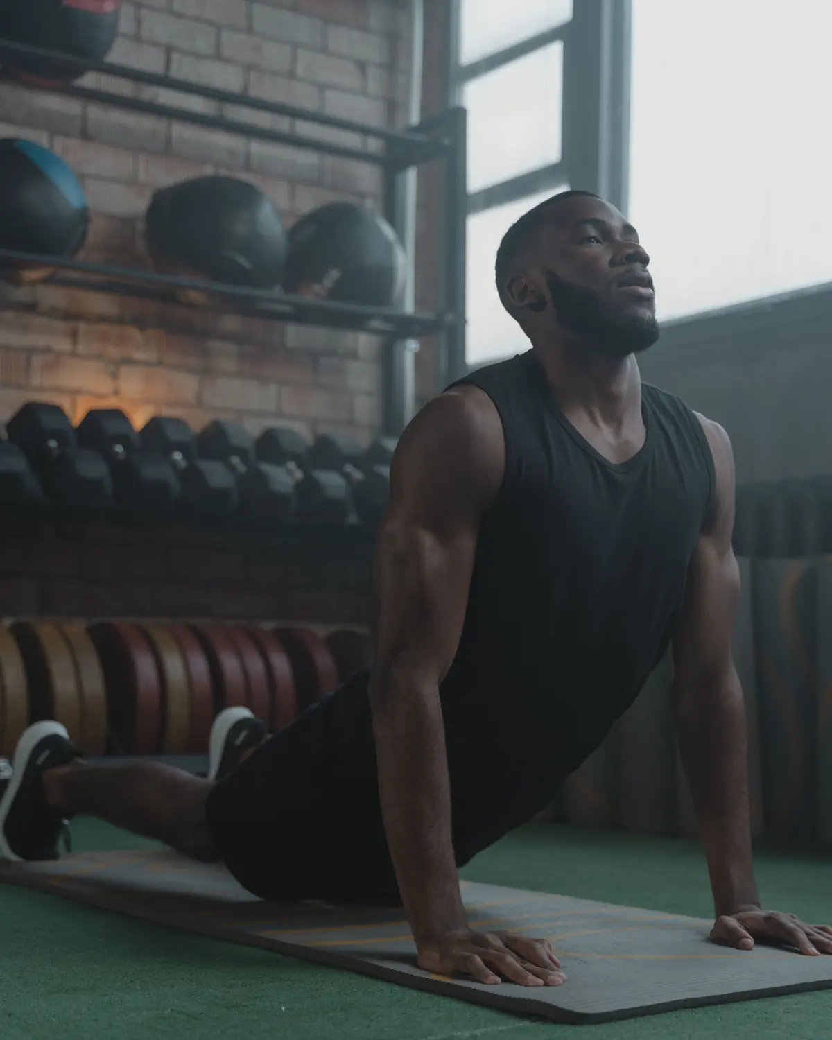 An athlete holds an upward-facing stretch on a mat