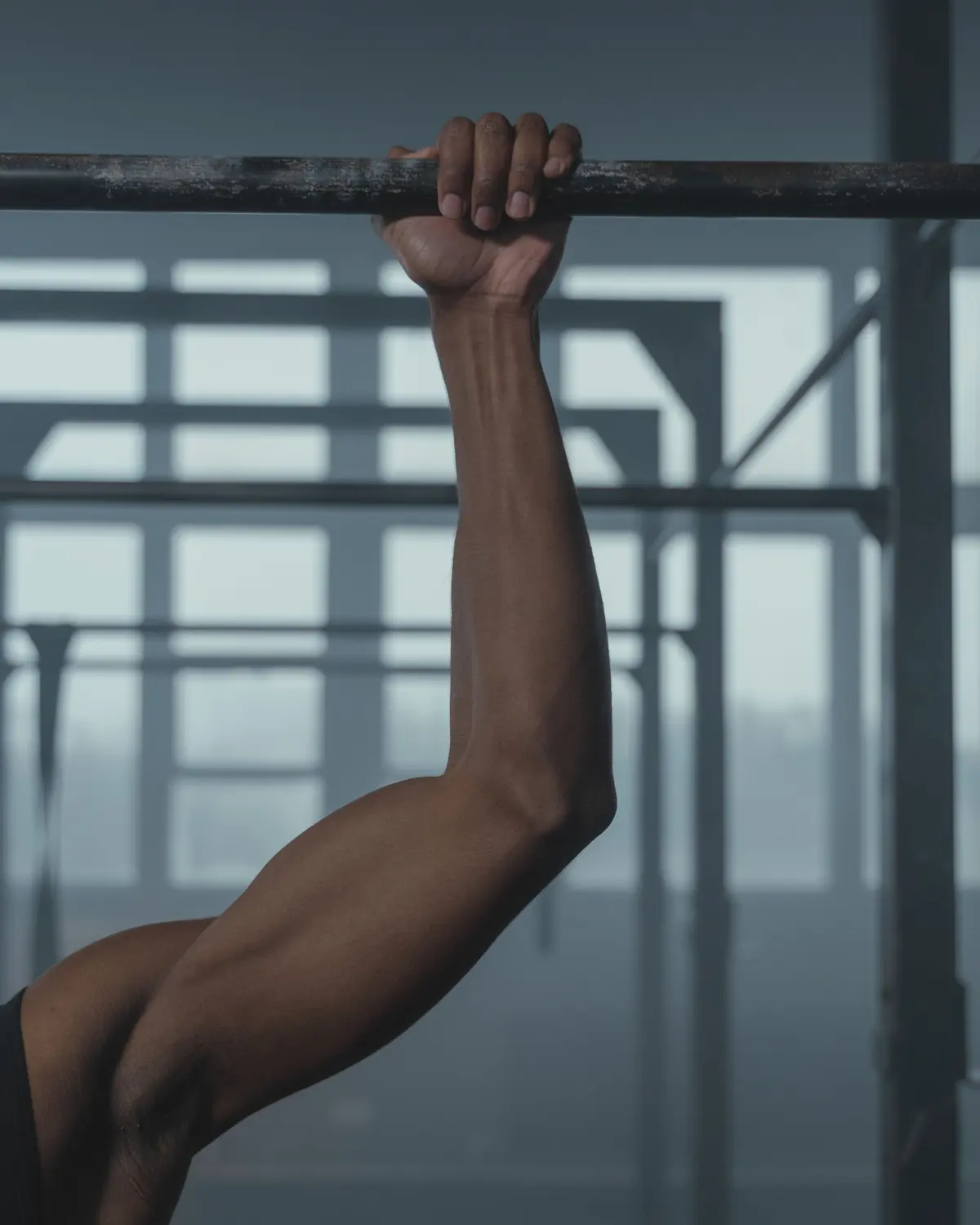 A hand grips the pull-up bar of the rig