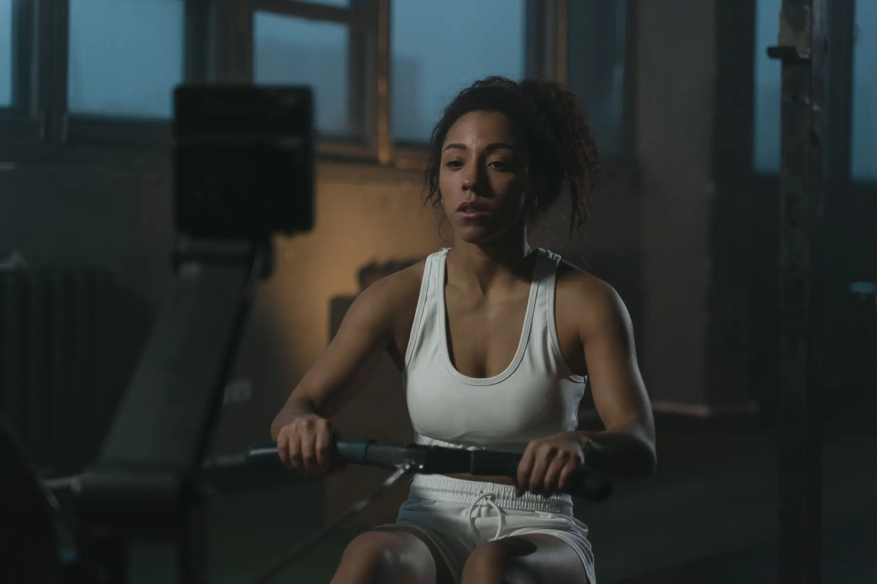 Mara on the rower in warm window light