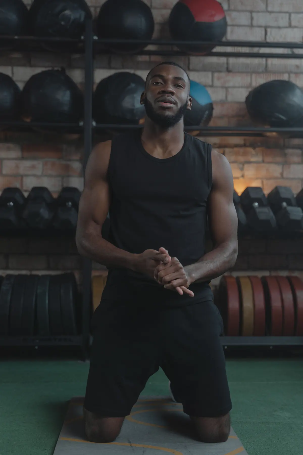 Theo kneeling in front of the medicine-ball wall