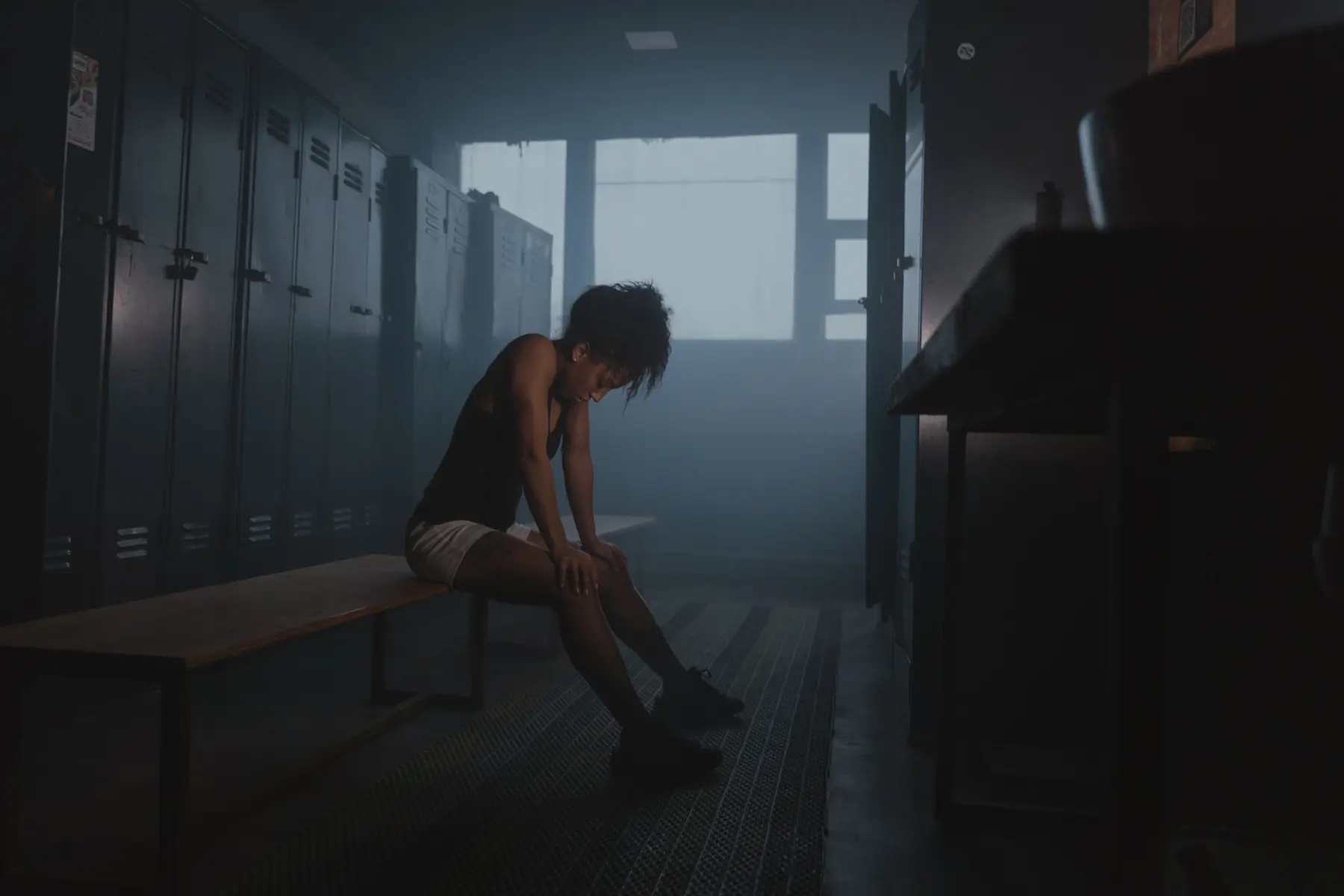 An athlete sits on the changing-room bench in the haze